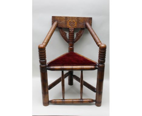 A 19th century Warwick turner's chair of typical bobbin design with chip carved back and triangular plank seat, 86 cm high 