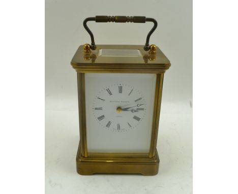 A MATTHEW NORMAN OF LONDON AN 8-DAY BRASS FRAMED CARRIAGE CLOCK, having bevelled glass panels, bale handle, 11-jewel movement
