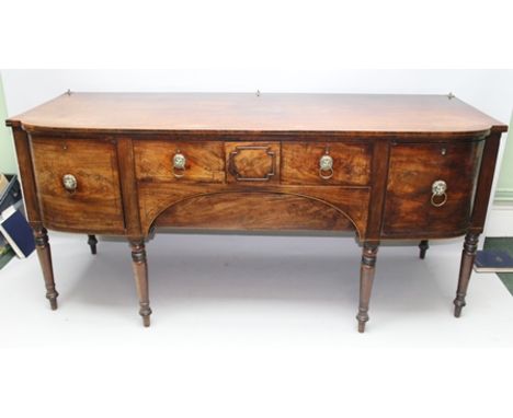 AN EARLY 19TH CENTURY MAHOGANY SIDEBOARD, having fitted drawers and cupboards with lion mask ring handles, raised on ring tur