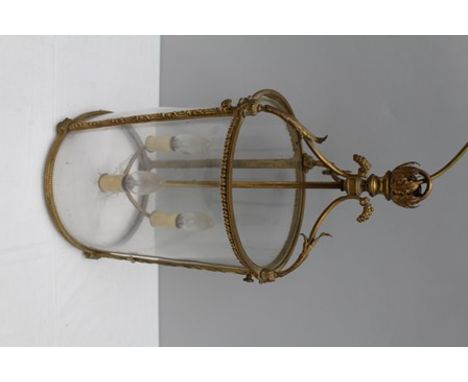 A FIRST QUARTER 20TH CENTURY GILT METAL FINISHED HANGING CYLINDRICAL GLAZED LANTERN with three sconce lamp fitting, 55cm high