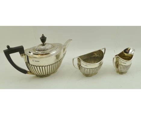 GEORGE EDWARD &amp; SONS AN EDWARDIAN SILVER THREE-PIECE BACHELOR TEA SET, comprising fluted teapot, two-handled sugar bowl a