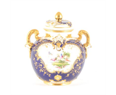 A Royal Worcester twin-handled vase and cover, the reserve painted with exotic birds in a landscape, enclosed by scrolled gil