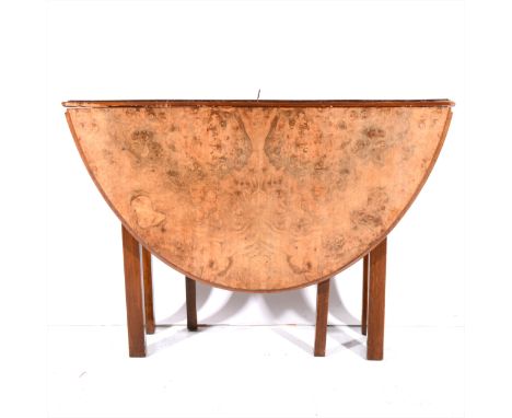 A figured walnut drop-leaf table, adapted, oval top on a later gate leg base, 140cm x 106cm.