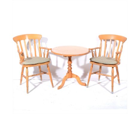 A modern pine pedestal table, circular top, tripod legs, diameter 67cm; and a pair of beechwood kitchen elbow chairs. (Qty: 3