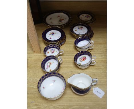A Royal Worcester part tea service, painted with flower sprays by Ernest Phillips and Ernest Barker, comprising: seven cups, 