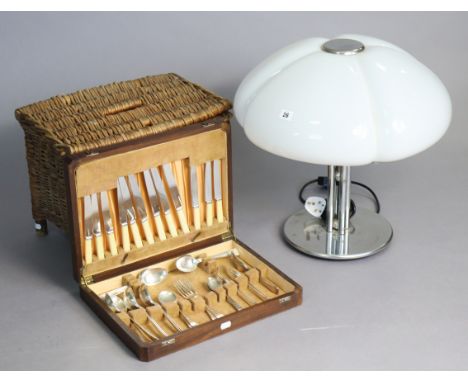 A contemporary silvered-metal table lamp with a white plastic domed shade, 19¾” high; a part canteen of cutlery in a walnut c