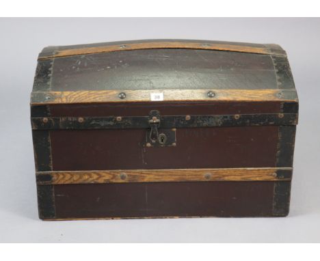 An early 20th century small leatherette-covered oak domed-top travelling trunk with a hinged lift-lid, &amp; with wrought-iro