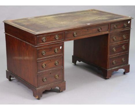 A Victorian mahogany pedestal desk inset with tooled leather top, fitted with an arrangement of nine drawers having brass rin