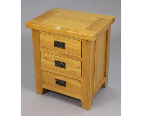 A light oak bedside chest fitted three long drawers, 21½” wide x 25” high.