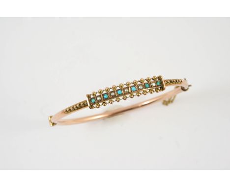 AN EDWARDIAN GOLD, TURQUOISE AND PEARL SET HALF HINGED BANGLE set to one side with ball and wirework decoration, mounted with