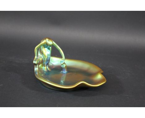 ZSOLNAY DISH a shallow Art Nouveau leaf shaped dish with a lady filling a pitcher, covered with a eosin lustre glaze. Marked,