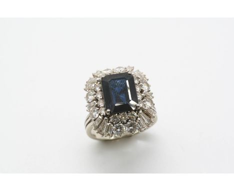 A SAPPHIRE AND DIAMOND CLUSTER RING the rectangular-shaped sapphire is set within a surround of tapered baguette-cut diamonds