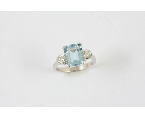 AN AQUAMARINE AND DIAMOND THREE STONE RING the step-cut aquamarine is set with two circular-cut diamonds in 18ct white gold. 