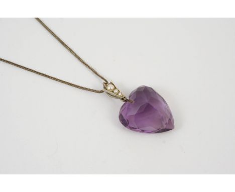 AN AMETHYST AND PEARL HEART-SHAPED PENDANT the heart-shaped amethyst is set with three graduated half pearls to the bale, 4cm