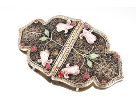 A white metal and enamel decorated buckle set with red stones; a white metal and enamel pendant set with turquoise stones and