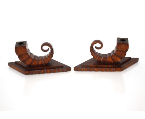 A pair of Art Deco oak Cornucopia dwarf candlesticks with square bobbin stems and angled asymmetrical bases, 25cm 