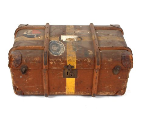 A wooden bound travelling trunk with various labels