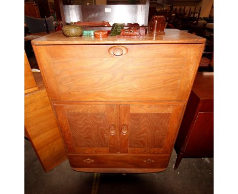 A light Ercol bureau fitted drop front compartment above cupboard doors and single drawer, 82cm wide x 48cm deep x 110cm high