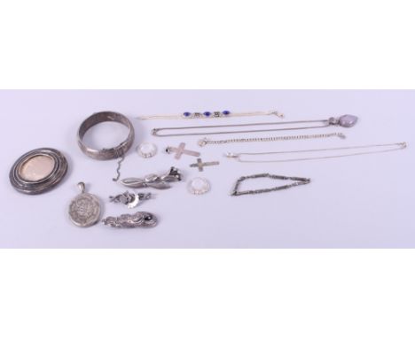 A quantity of silver and white metal jewellery, including a silver bangle, bracelets, brooches, necklaces and a silver photog