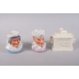 A pair of 19th century porcelain Punch and Judy jugs, 5" high, and a butter dish and cover