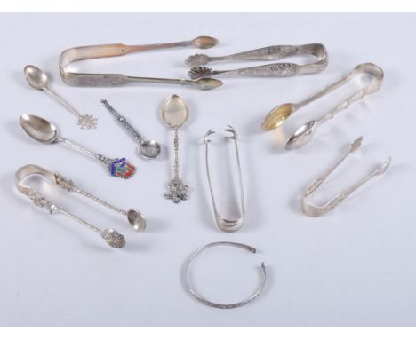 Two pairs of silver sugar tongs, a Celtic design silver spoon, a child's silver bangle and various other silver and white met
