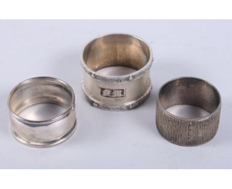 A textured silver napkin ring and two other silver napkin rings, 3oz troy approx