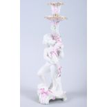A 19th century Continental bisque porcelain candlestick with putto and scroll base, 10 3/4" high