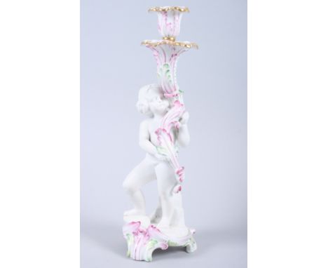 A 19th century Continental bisque porcelain candlestick with putto and scroll base, 10 3/4" high Condition report:Chip to bas