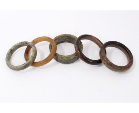 Five Chinese carved jade or hardstone bangles the largest 9cm diameter.Provenance: acquired in Malaysia by a private collecto