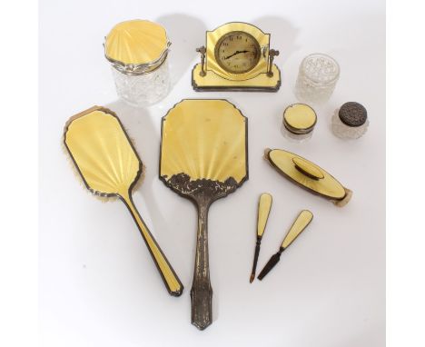 Selection of Art Deco period silver and yellow guilloche enamel dressing tableware - including a clock, toilet jars, hand mir