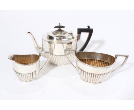 George V silver teapot of half fluted form with angular ebony handle and hinged domed and fluted cover with ebony finial, mat