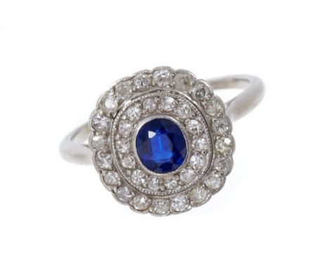 1920s sapphire and diamond cluster ring, the central oval mixed cut blue sapphire surrounded by a two-tiered concentric oval 