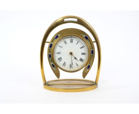 Victorian brass desk clock with circular movement and white enamel dial surrounded by a horseshoe with blue enamelled nails, 