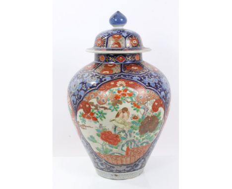 Late 19th century Japanese Imari baluster vase and cover with polychrome enamel bird and shi shi dog reserves on floral groun