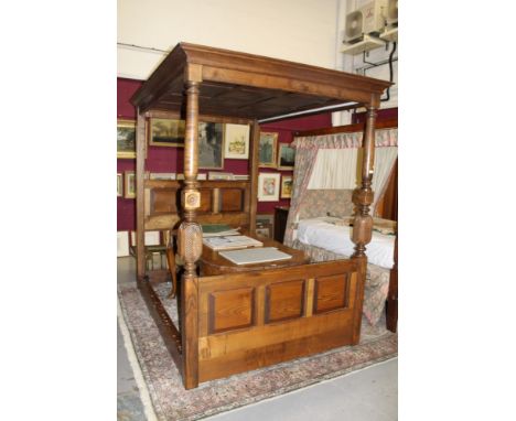 Modern oak four poster bed in the 17th century style with canopy top and fielded panel head and foot with lead and rosette pi