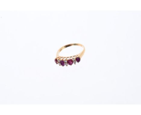 Ruby and diamond ring with four oval mixed cut rubies interspaced by six brilliant cut diamonds in claw setting on gold shank