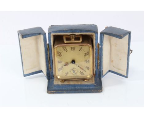 1930s French travelling alarm clock in gilt case raised on bun feet in original case, 8cm high