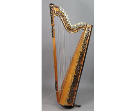 A modern carved wooden floor-standing harp (slight faults – one string loose, requires stand), 150cm high.