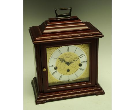 A Hermle bracket clock, Westminster chime, silvered chapter ring with Roman numerals, three winding holes, brass carry handle