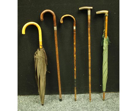 A silver mounted walking stick; two others, similar; two umbrellas (5)