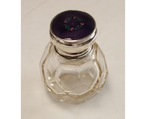 An early 20th century multi-faceted glass scent or smelling salts bottle, silver and guilloche enamel screw top, glass stoppe