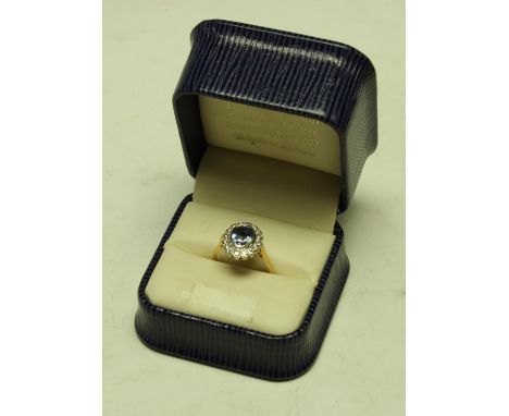 An 18ct gold dress ring, central faceted blue stone surrounded by sixteen diamonds, 4.7g