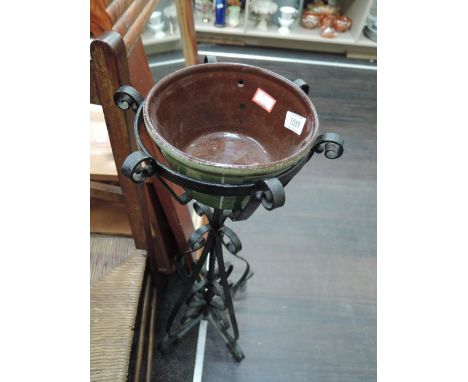 A vintage wrought iron planter stand