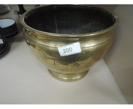 A large brass planter with bird and water themes