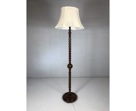 Carved wooden standard lamp with spiralling snake and ball relief design and cream shade