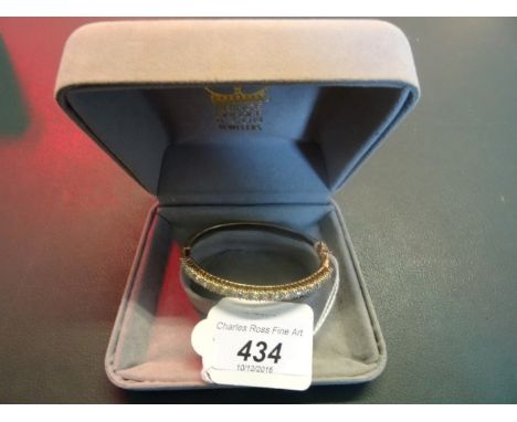 A diamond set hinged bangle, the centre set with a continuous band of claw mounted brilliant cut diamonds, push button clasp,