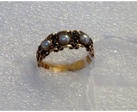 A mid-19th century emerald and split pearl half-hoop ring, in pierced and engraved scroll mounts, with foliate engraved shank