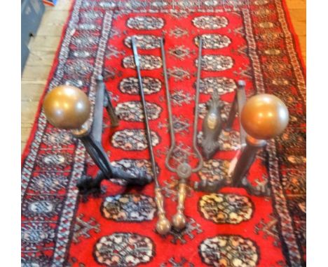 A pair of 19th century brass and cast iron fire dogs, together with assorted fire tools.