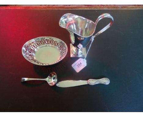 A silver cream jug on square pedestal, together with a sterling silver sweet meat bowl, a small silver ladle and a white meta