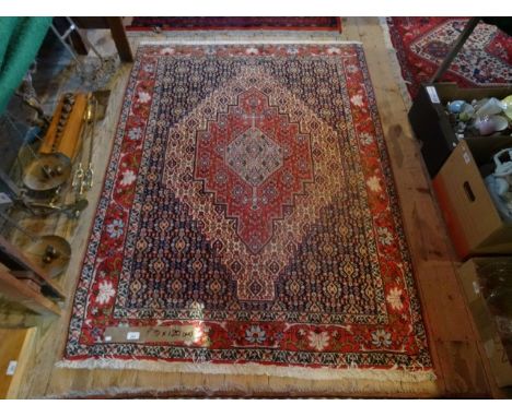 A contemporary machine made carpet, the diamond central lozenge having Persian stylized shapes (120cm x 170cm).